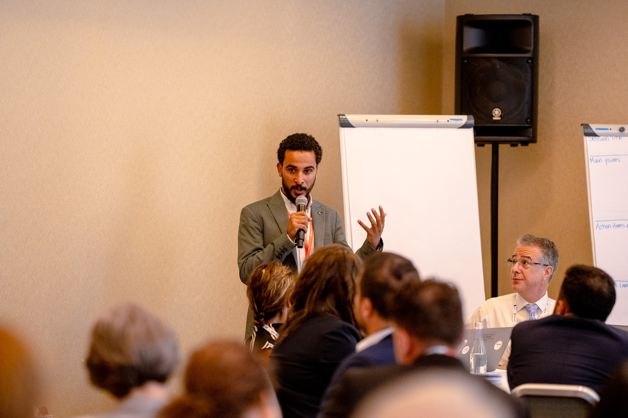Khaled Emam speaking at the 2025 World Justice Forum, addressing attendees in a conference room.